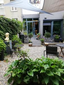 een tuin met stoelen, tafels en planten bij Guesthouse Marie Therese in Brussel