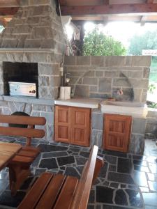 a kitchen with a stone fireplace with wooden tables and chairs at Rooms & Apartments Giulia in Portorož