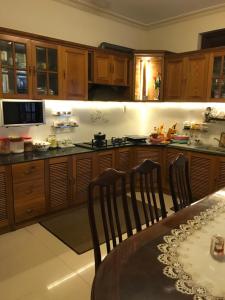 a kitchen with wooden cabinets and a table with chairs at Hostel Phuong Nga in Da Lat