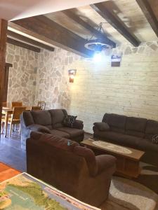 a living room with couches and a stone wall at Holiday Home Ivana in Virpazar