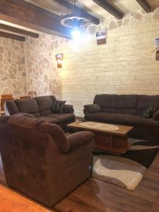 a living room with two couches and a table at Holiday Home Ivana in Virpazar