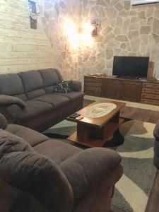 uma sala de estar com dois sofás e uma mesa de centro em Holiday Home Ivana em Virpazar