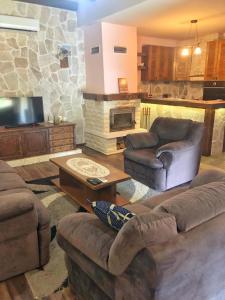 a living room with couches and a stone fireplace at Holiday Home Ivana in Virpazar