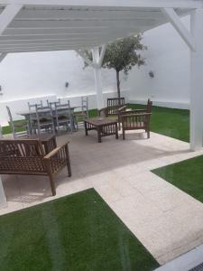 a group of benches sitting under a pavilion with grass at White House & B. in Sìnnai