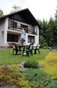 a house with a picnic table and chairs in the yard at Spacious house at the gate of Giant Mountains in Víchová nad Jizerou