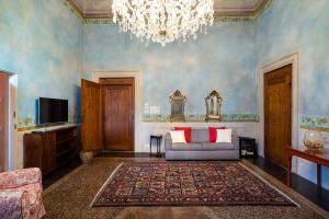 un soggiorno con divano e lampadario pendente di Torre dei Lari Residenza d'Epoca a Firenze