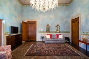 a living room with a couch and a chandelier at Torre dei Lari Residenza d'Epoca in Florence