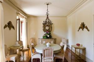 a dining room with a table and a clock on the wall at Villa Barberina in Valdobbiadene