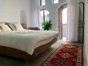 um quarto com uma cama grande e um tapete vermelho em Daya - Old City Acre em Acre