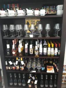 a shelf full of wine bottles and glasses at White House & B. in Sìnnai
