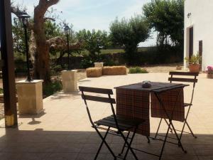 a table and chairs in a patio with a table and chairs at Masseria Chianca - Le rose in Mottola