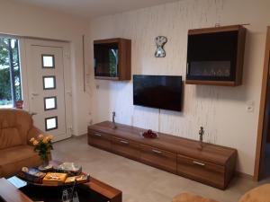 a living room with a couch and a flat screen tv at Ferienwohnung am Sorpesee in Allendorf