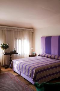 ein Schlafzimmer mit einem großen Bett mit violetter Bettwäsche in der Unterkunft Villa Barberina in Valdobbiadene