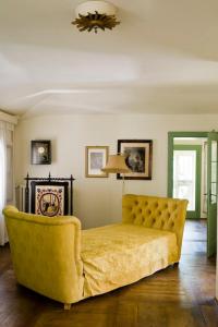 a living room with a yellow couch and a lamp at Villa Barberina in Valdobbiadene
