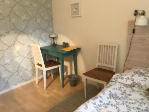 a bedroom with a green desk with a bed and a table at Tant Grön B&B in Falun