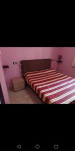 シャッカにあるAppartamentini San Marcoのベッドルーム1室(ストライプ毛布付きのベッド1台付)