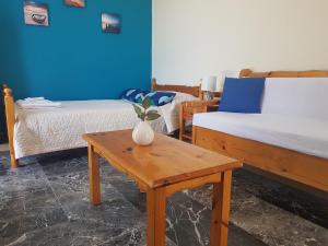 a room with two beds and a table with a vase on it at Gkionis Apartment in Kalamata