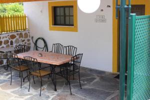 une table et des chaises installées à côté d'un bâtiment dans l'établissement Quinta de Vale Escuro, à Lousã
