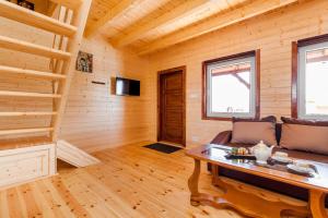 a log cabin living room with a couch and a table at Osada Chłapowo in Władysławowo