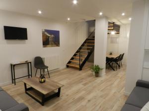 a living room with a staircase and a table at Tu Casa en Santander in Santander