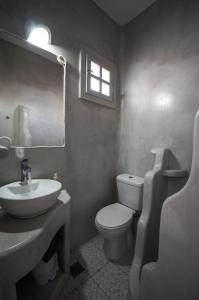 a bathroom with a sink and a toilet and a window at Anerousses in Adamas