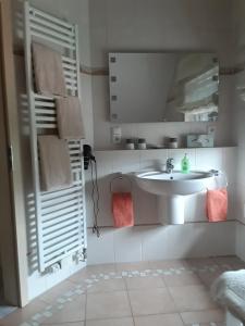 a white bathroom with a sink and a mirror at Ferienwohnung Reddemann in Westerstede +21 photos