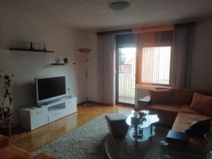 a living room with a couch and a television at Apartman AS in Livno