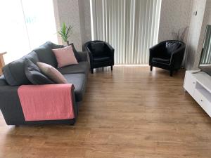 a living room with a couch and two chairs at Coed Bach Suite in Bryngwran