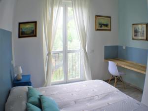 Un dormitorio con una cama y una ventana grande. en CaseMaggi Beach House Terrace, en Portovenere