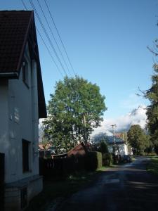 a house on a street with a mountain in the background at Privat Lucia in Nová Lesná