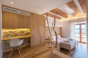 a bedroom with a bed and a desk in a room at Can Cota Boutique - Turismo de interior in El Port de la Selva