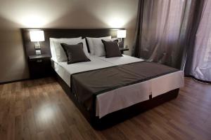a bedroom with a large bed with two lamps at Soho Apartments in Bitola