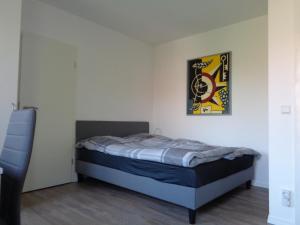 a bedroom with a bed and a picture on the wall at Studiozimmer an den Leineauen in Arnum