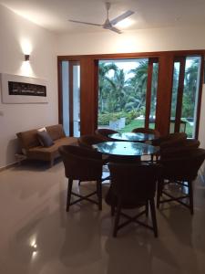 uma sala de estar com uma mesa e cadeiras e um sofá em Colibri Villa em Maggona West