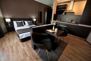 Habitación de hotel con 2 camas, mesa y sillas en Soho Apartments, en Bitola