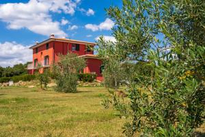 una casa roja en medio de un campo en Villa Liburnia, en Livorno