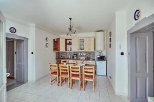 a kitchen with a table and chairs in a room at Twin Pines Apartment - Ikerfenyők apartman in Egerszalók