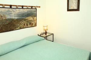 een slaapkamer met een bed en een schilderij aan de muur bij Borgo del Barone in Carini