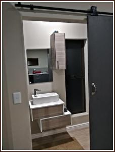 a bathroom with a sink and a mirror at Studio 77 in Langebaan