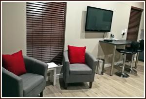 a living room with two chairs and a television at Studio 77 in Langebaan