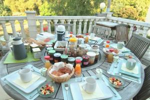 einen Tisch mit Teller mit Speisen auf einer Terrasse in der Unterkunft La Lambertine & Spa in Saumur