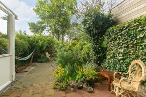 een tuin met stoelen en planten en een hek bij Residentie Blijdorp in Rotterdam