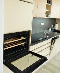 a kitchen with an open refrigerator with wine glasses at Rezidence Pálava in Pavlov