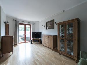 ein großes Wohnzimmer mit einem TV und Holzböden in der Unterkunft OLSZA RESIDENCE Cozy & quiet 2 level apartment in Krakau