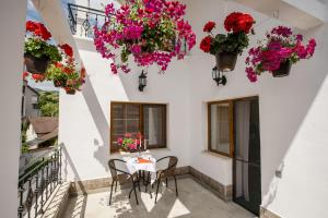 una mesa y sillas en un balcón con flores en Pensiunea Vila Europa, en Deva