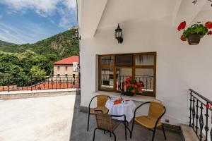 een tafel en stoelen op een balkon met uitzicht bij Pensiunea Vila Europa in Deva