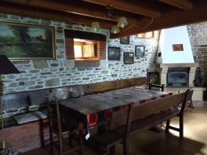 La Casa del Acebal في Solórzano: غرفة طعام مع طاولة وجدار حجري
