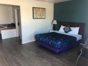 a bedroom with a bed and a dresser at 5000 Motel in Penticton