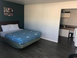 a bed in a room with a wooden floor at 5000 Motel in Penticton