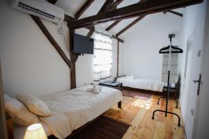 una camera con 2 letti in una stanza con pavimenti in legno di Epicenter a Niš